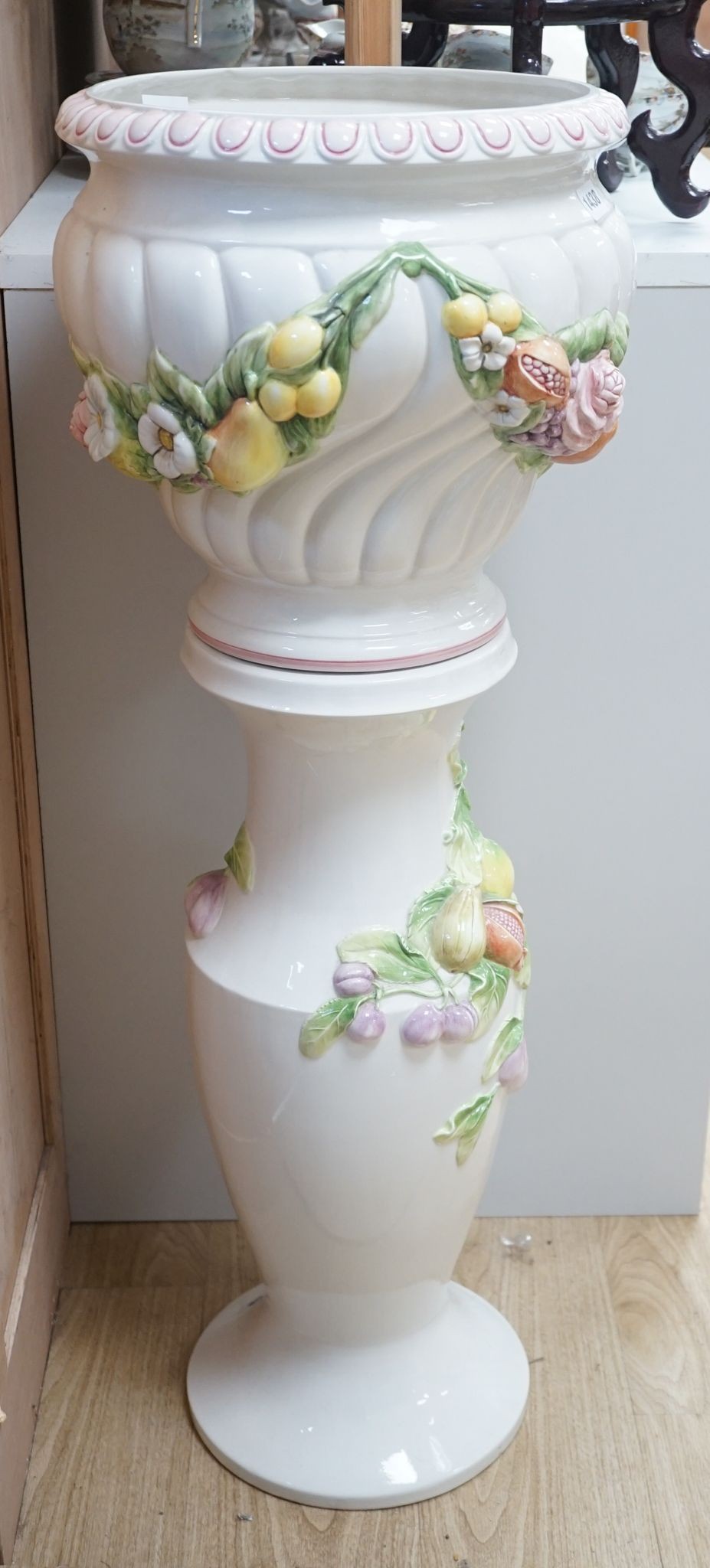 A modern Italian pottery jardiniere and stand, with floral and fruit decoration, 104 cms high.